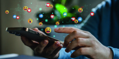 virtuelle Emoticons schweben über einem Handy